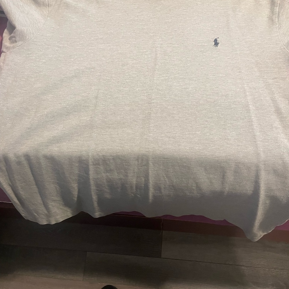 Polo shirt short sleeve grey in color with blue trim around the neck and arms.